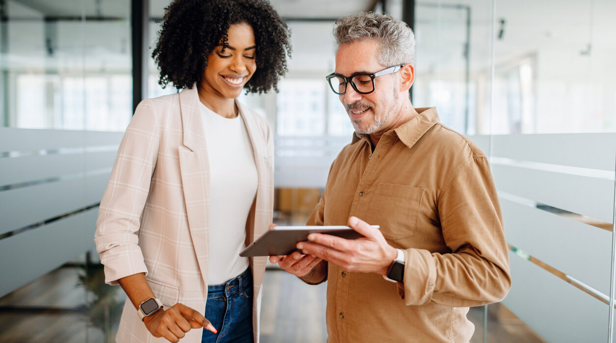 A businesswoman and a senior male colleague collaboratively review content