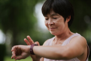 Mature woman using smartwatch at park