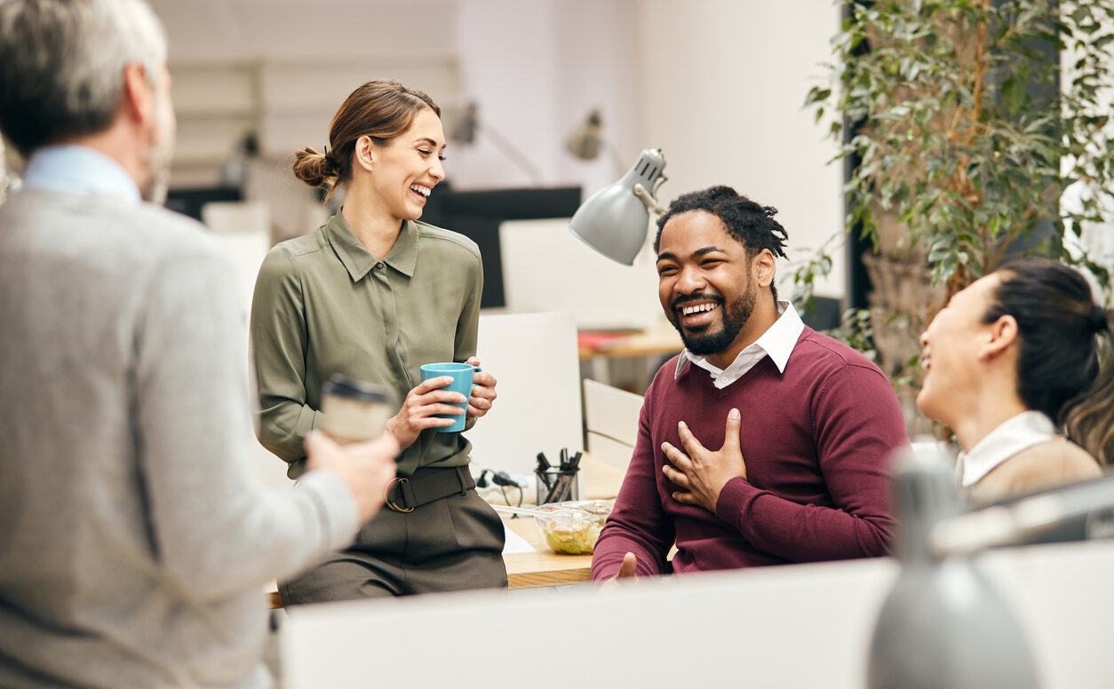 Happy business team having fun while talking on their coffee break in the office.