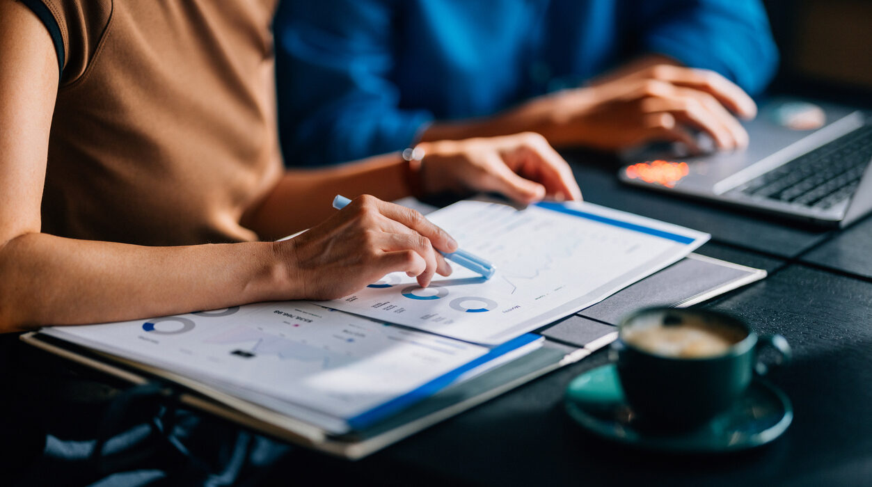Two colleagues reviewing financial data and charts