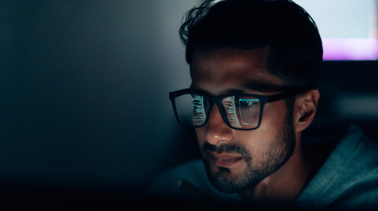 IT Specialist Concentrating on Data and Programming in a Dark, Tech-Driven Workspace